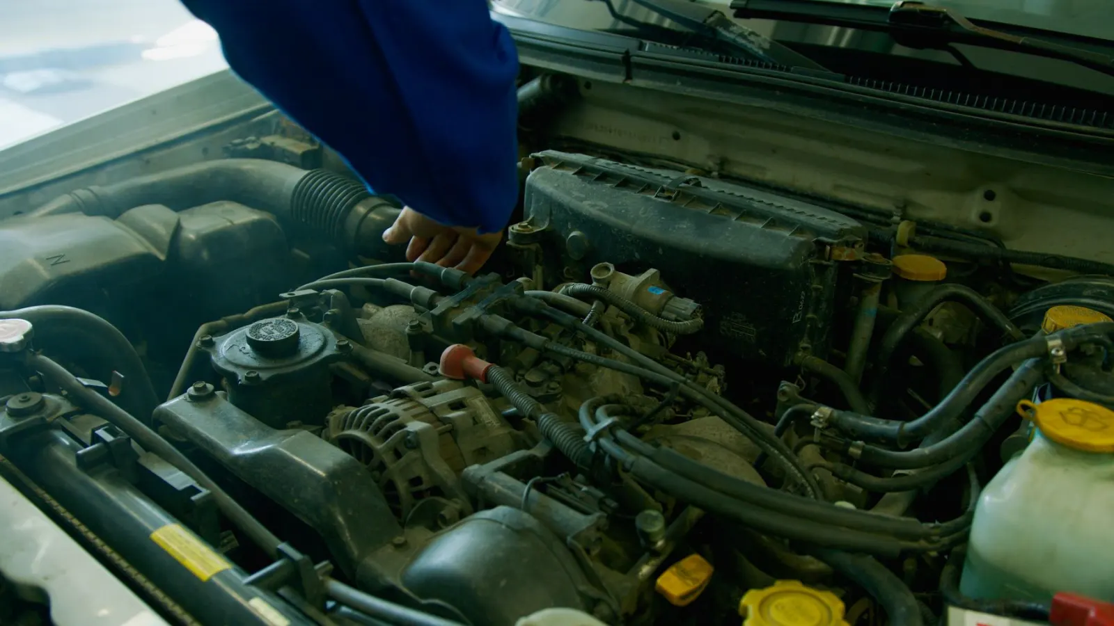 Main sur un cache moteur pendant le contrôle