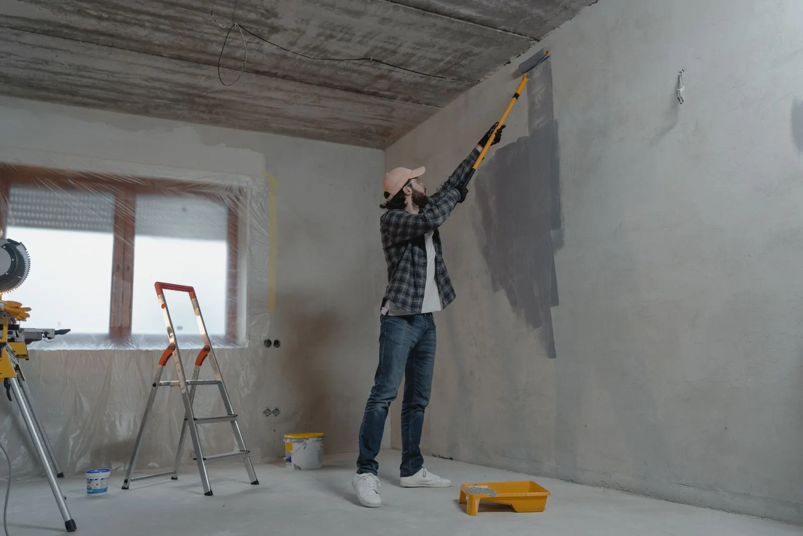 Peintre au rouleau sur un mur en préparation