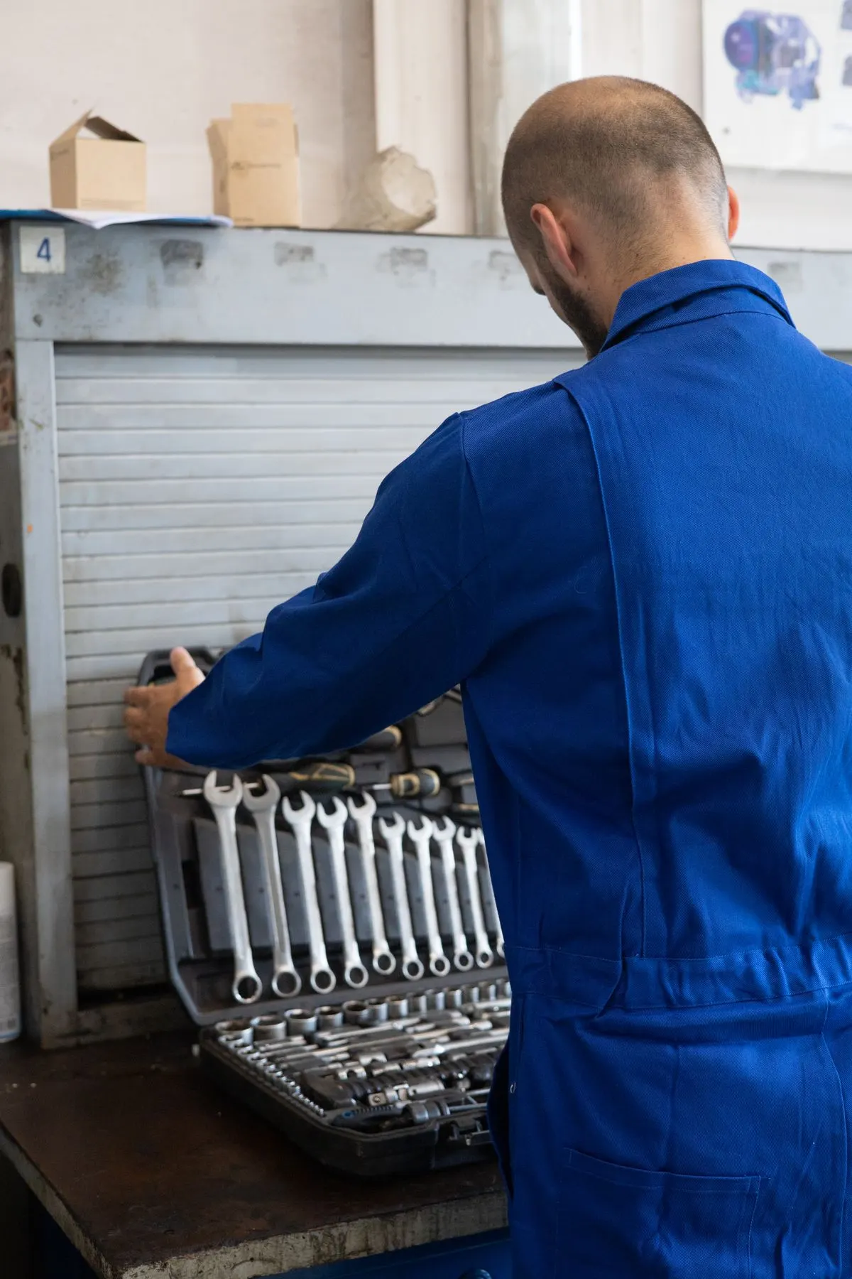 Artisan en bleu de travail avec ses outils