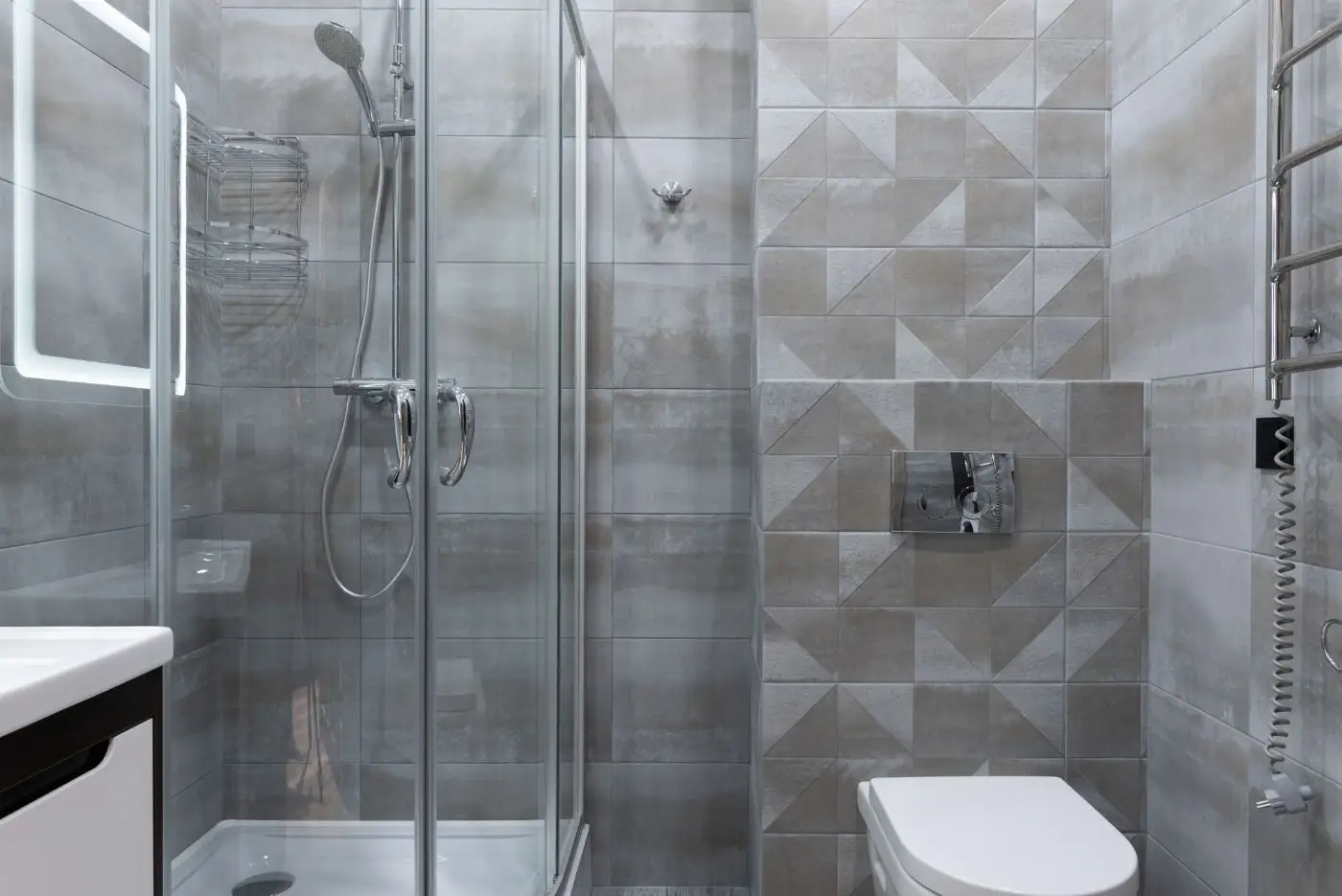 Cabine de douche vitrée, WC suspendu et carrelage gris
