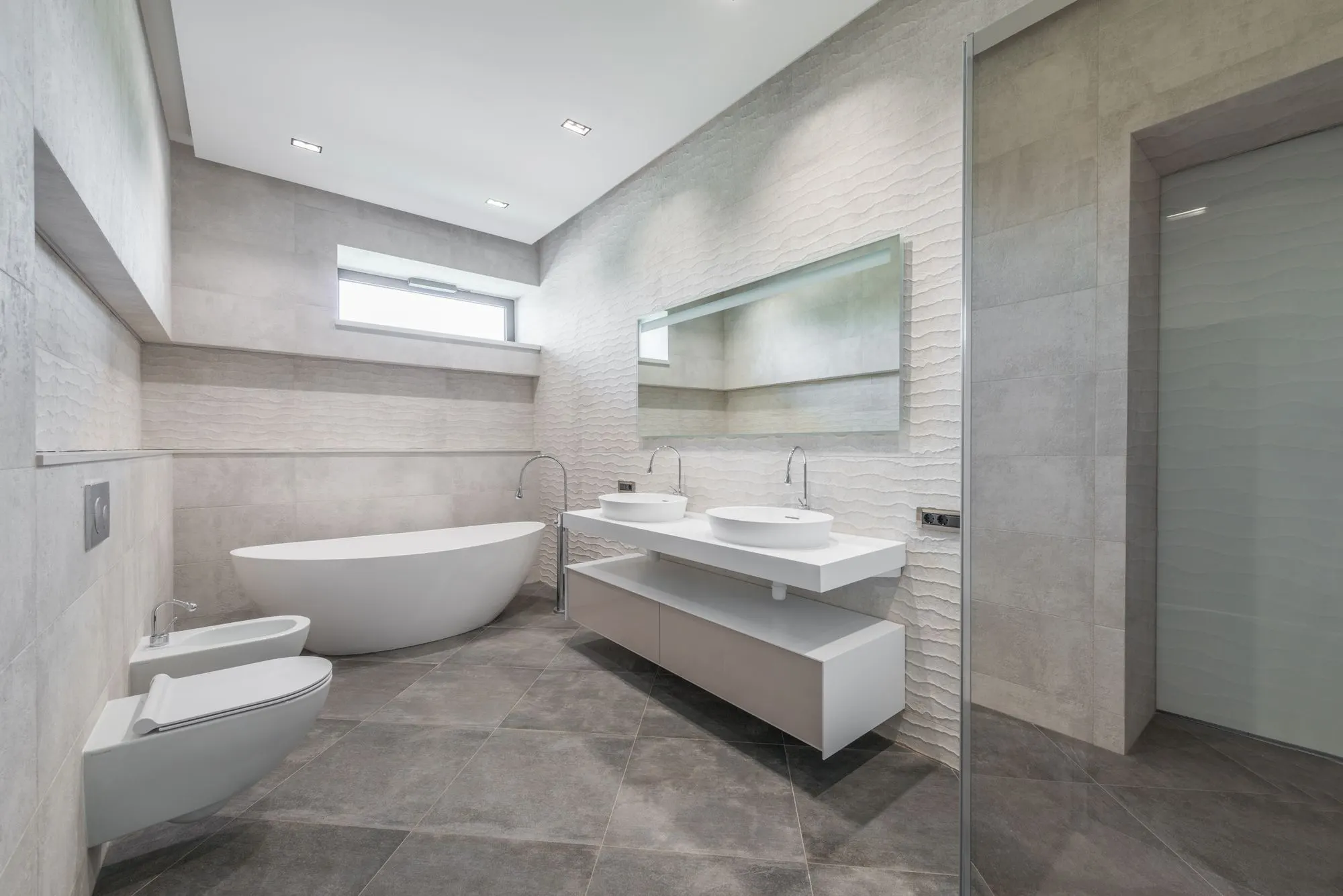 Salle de bains lumineuse avec baignoire îlot et double vasque